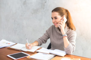 Female professional taking notes about how to conduct a phone interview