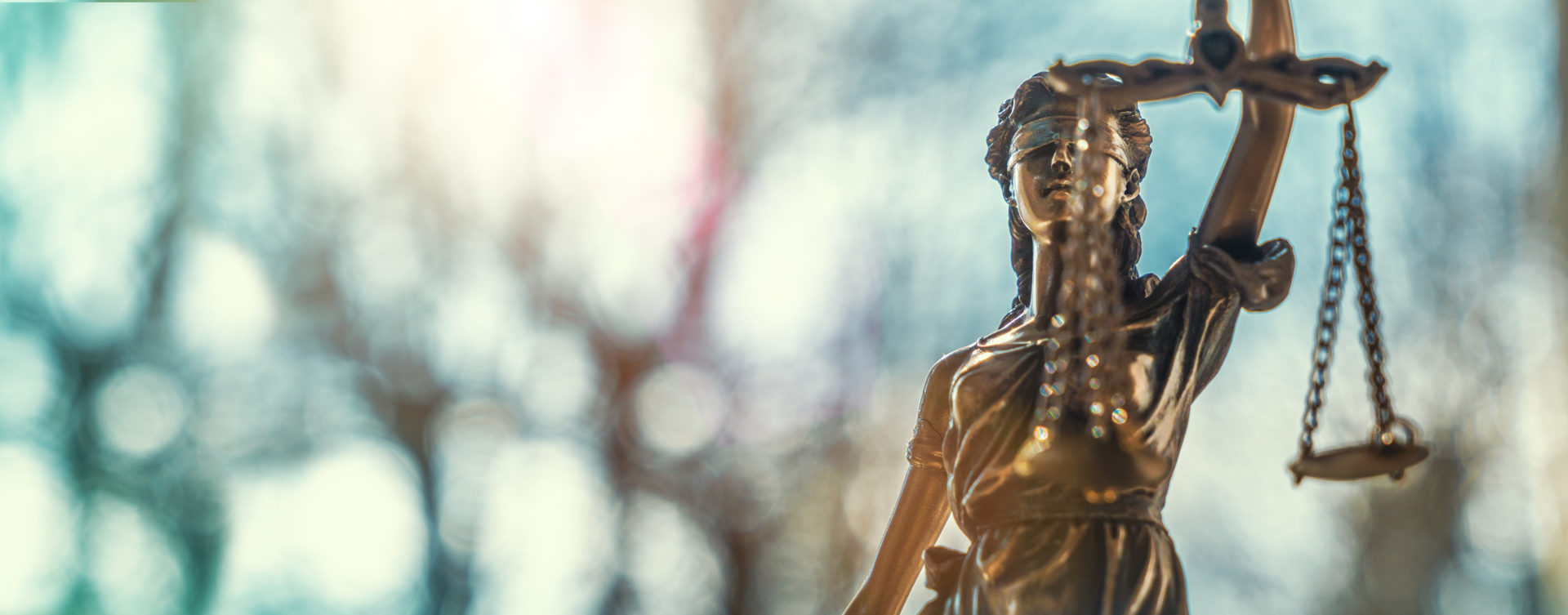 Gold statue of a woman blindfolded holding the scales of justice