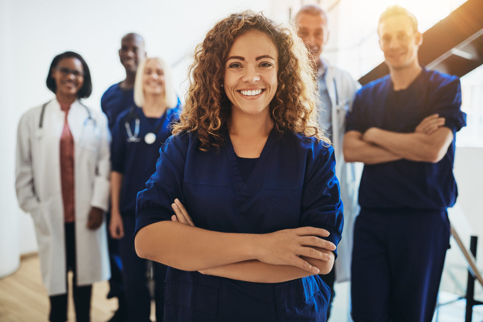 Female doctor wearing navy scrubs and smiling