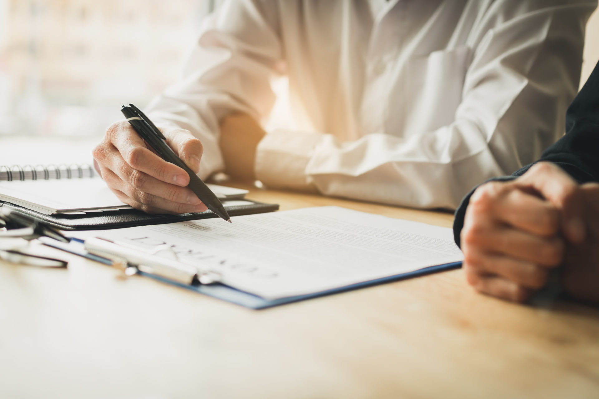 Male professional holding a pen and reading over paperwork