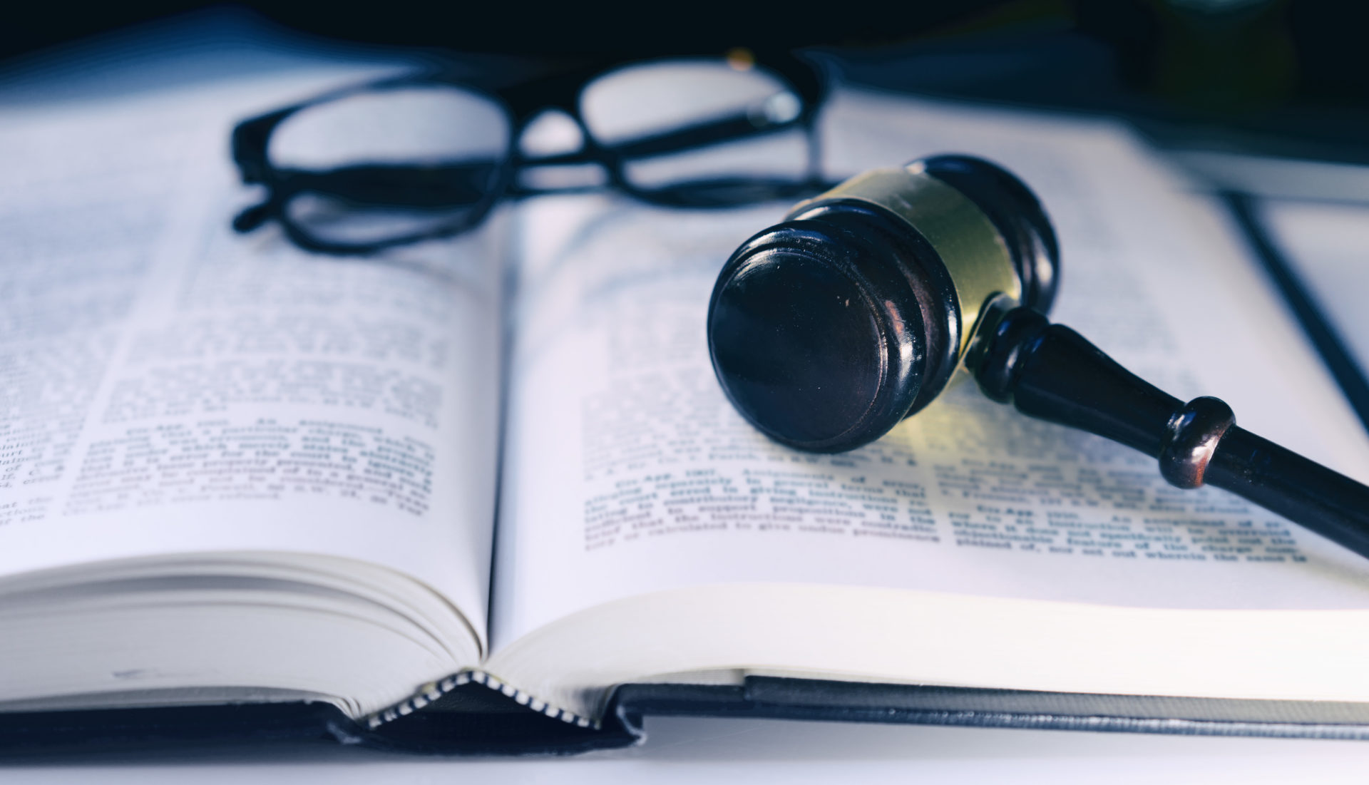 Opened book with glasses and a gavel laying on top