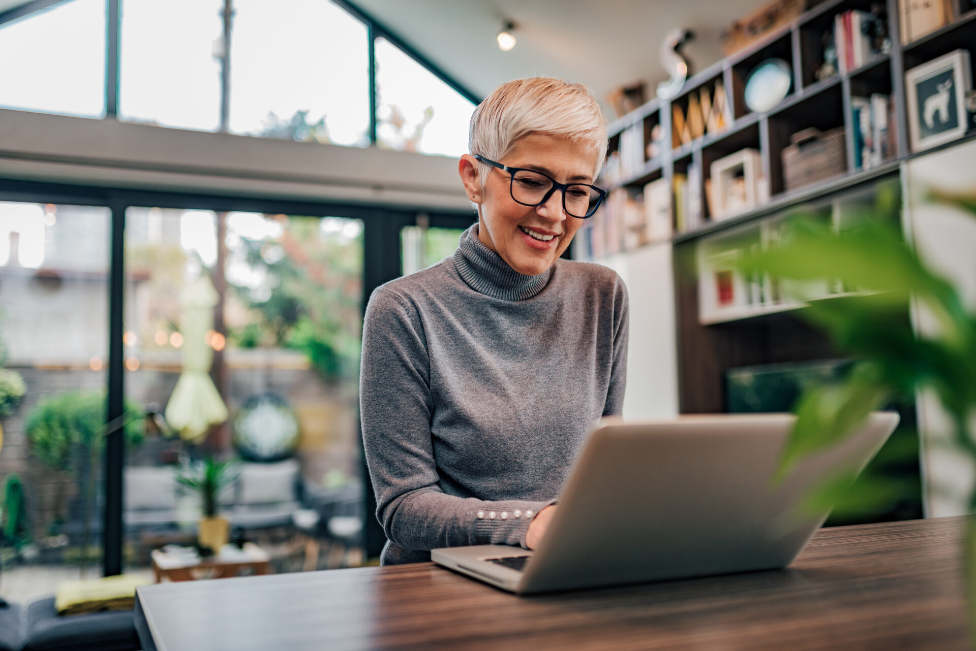 HR professional working on laptop at a modern home office conducting virtual onboarding