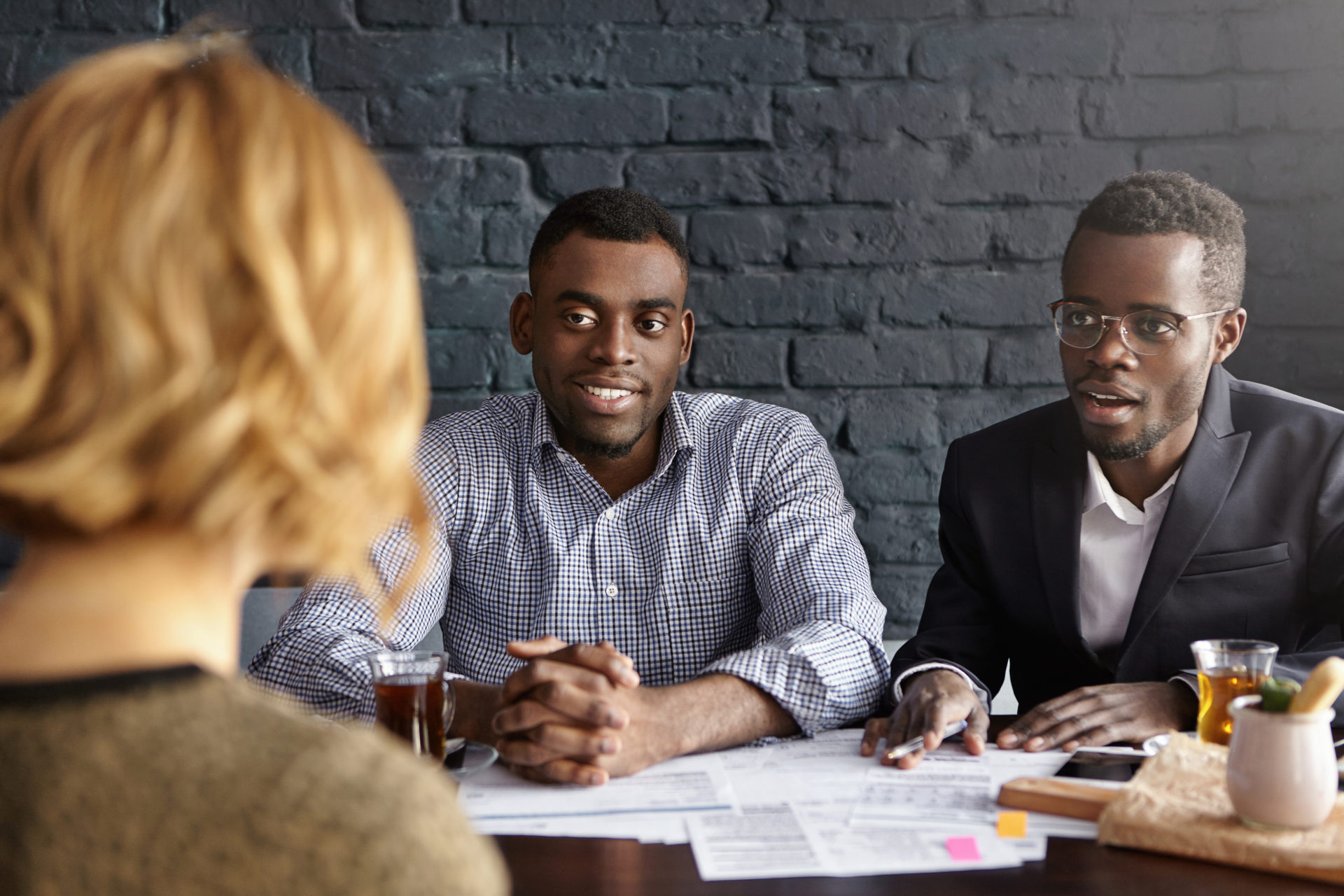 Three finance professionals talking and looking over paperwork