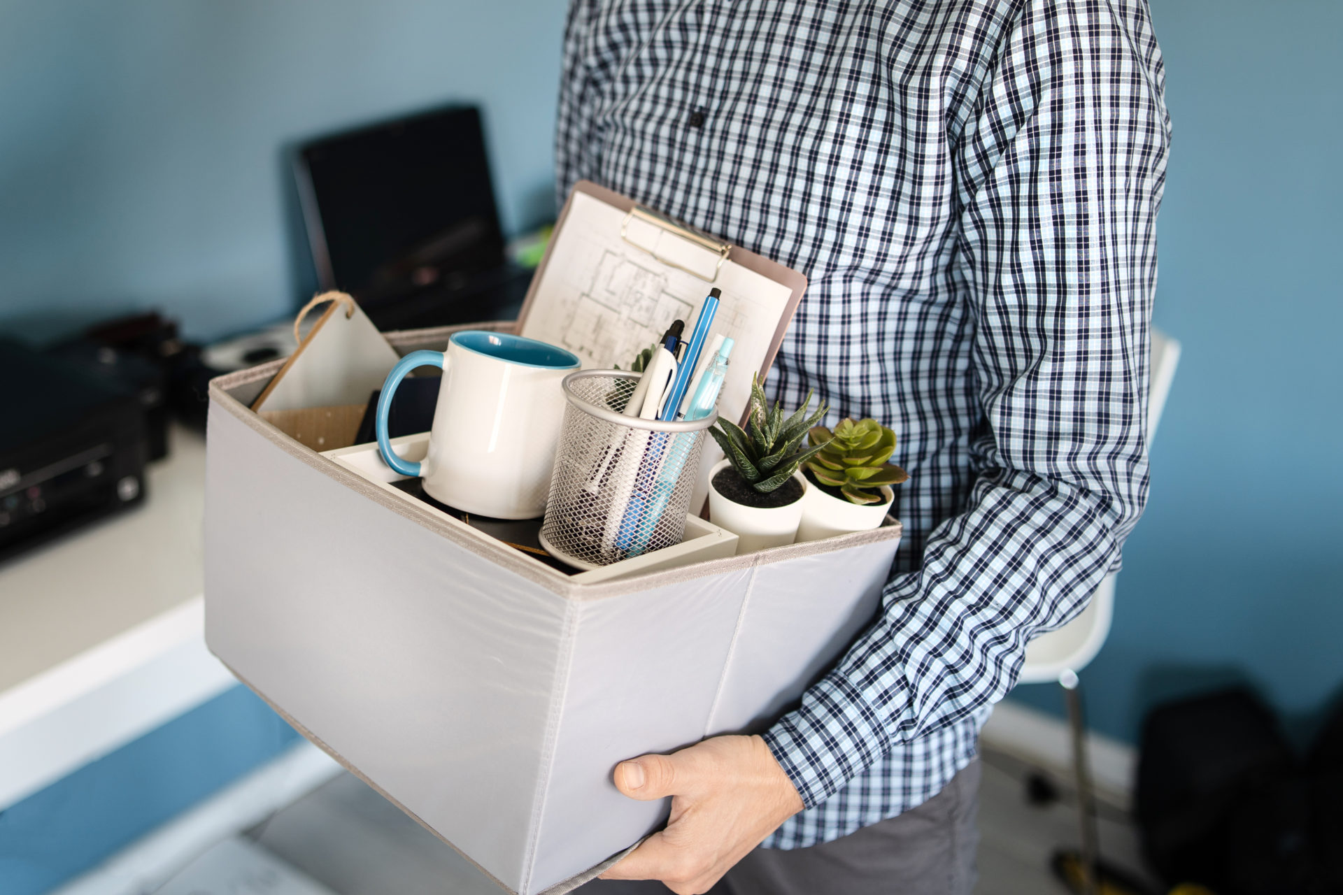 Professional who just got laid off holding a box of their things