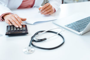 Female healthcare worker using a calculator