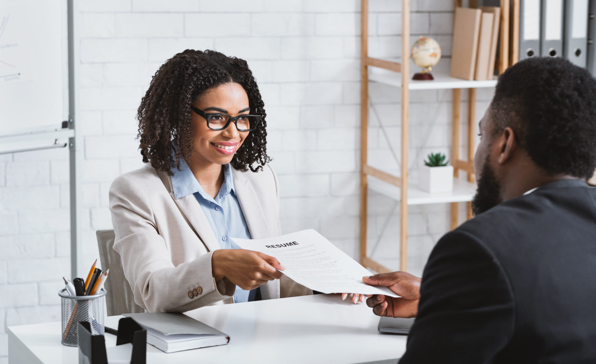 Female handing over a resume to a hiring manager