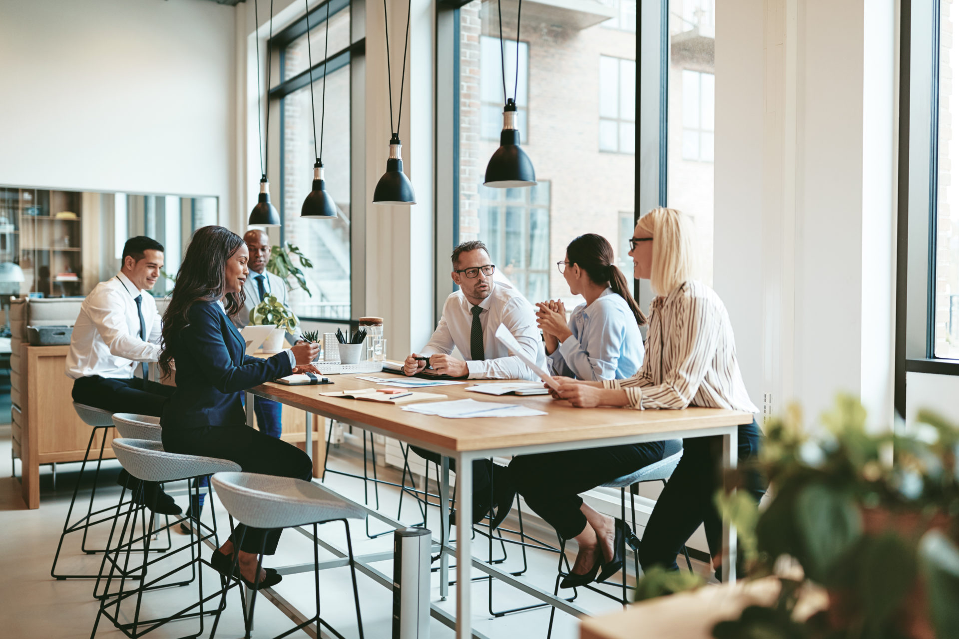  Groupe diversifié de professionnels assis autour d'une table conversant 