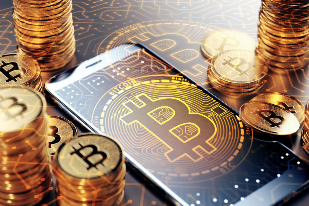 Bitcoin on cell phone surrounded by coins