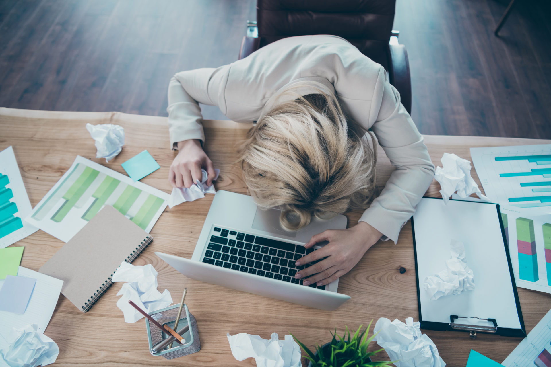 Business lady lying on desk with crumpled papers and task sheets