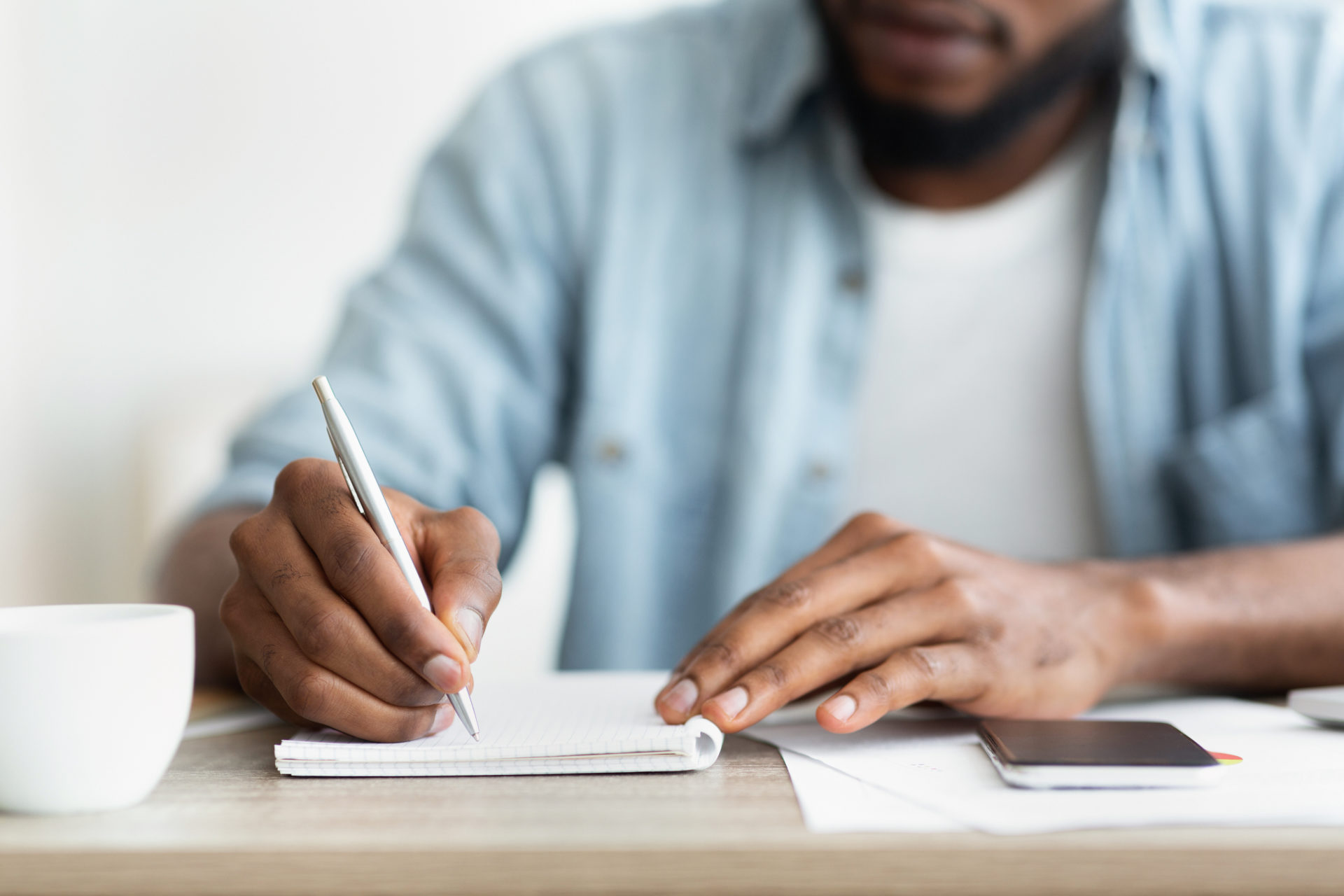 Employee writing a candidate rejection letter at his desk