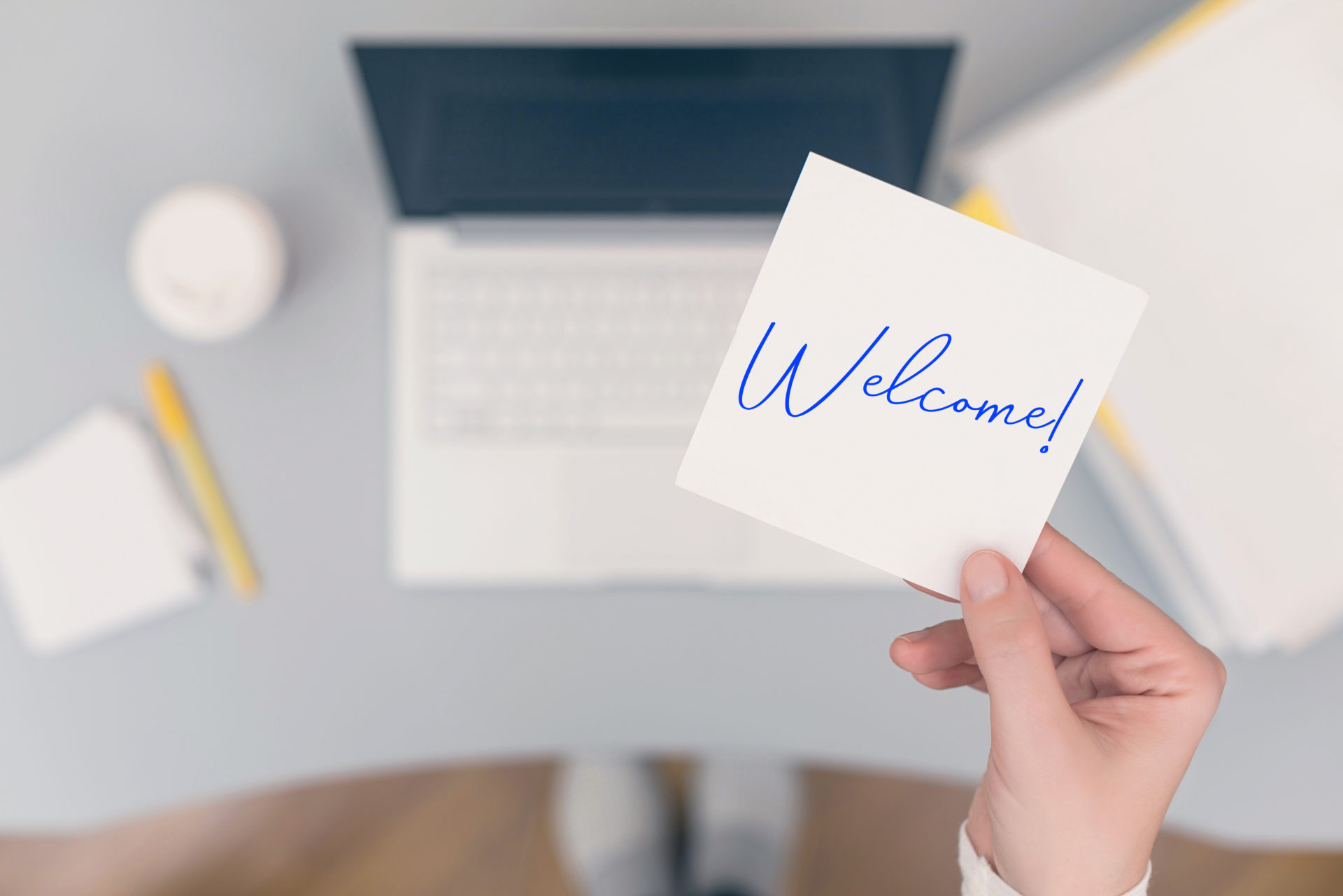 Woman professional sitting holding note paper sticker with Welcome word.