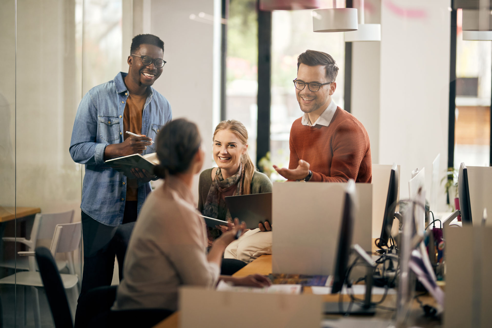 Group of diverse business colleagues communicating and having fun on a meeting in the office.