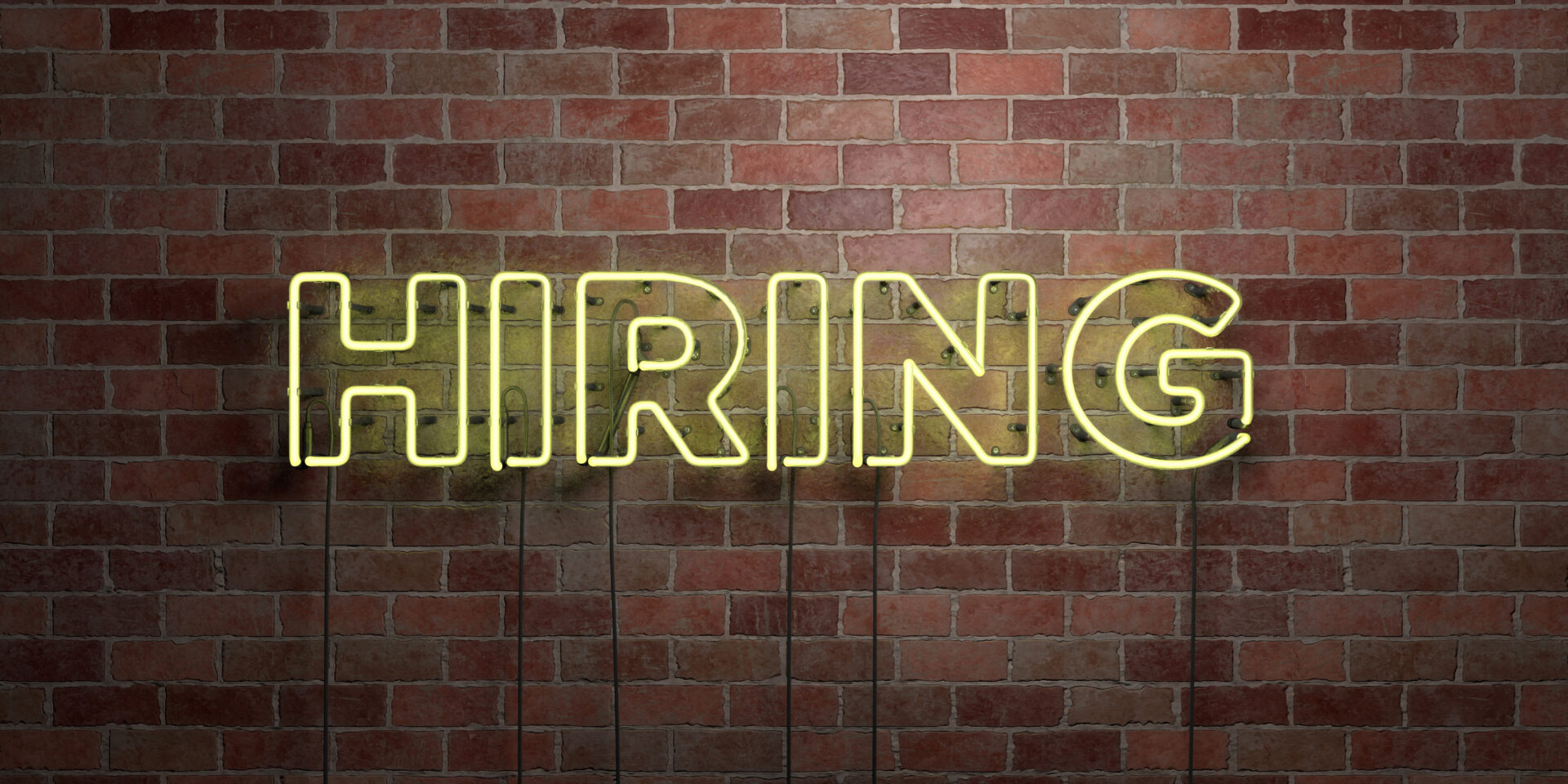 HIRING - fluorescent Neon tube Sign on brickwork. We are hiring social media concept image.
