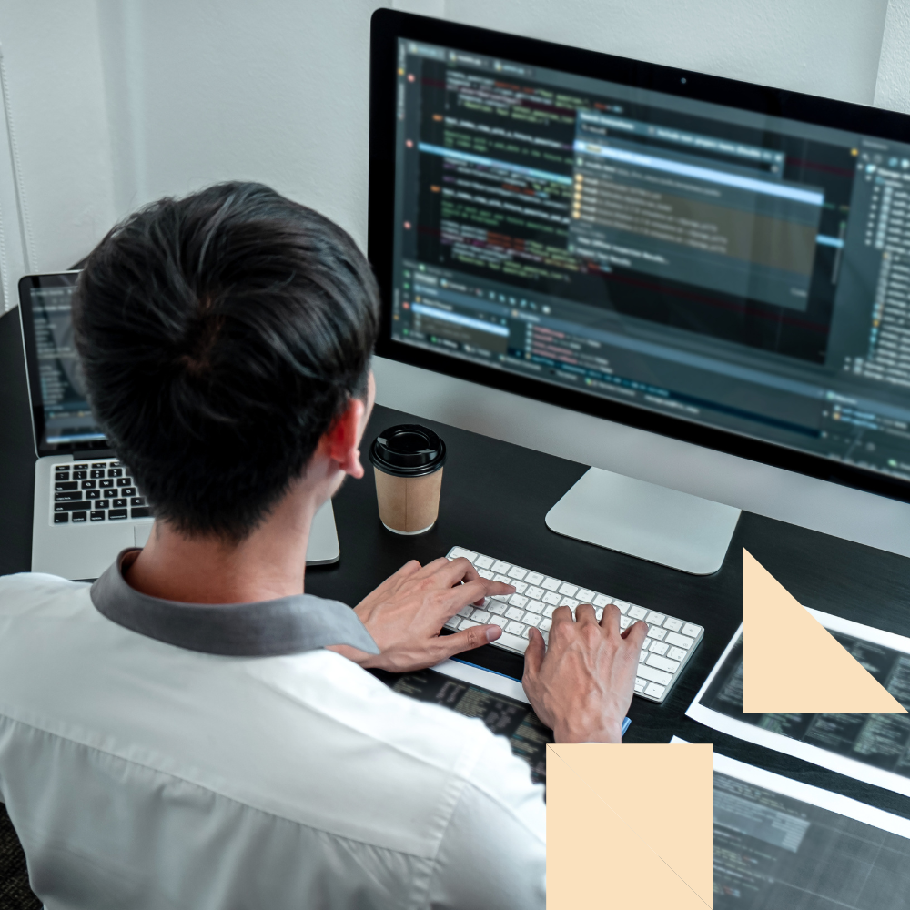 Young professional coding on a computer at a modern workspace, representing a technology career path with high growth opportunities.