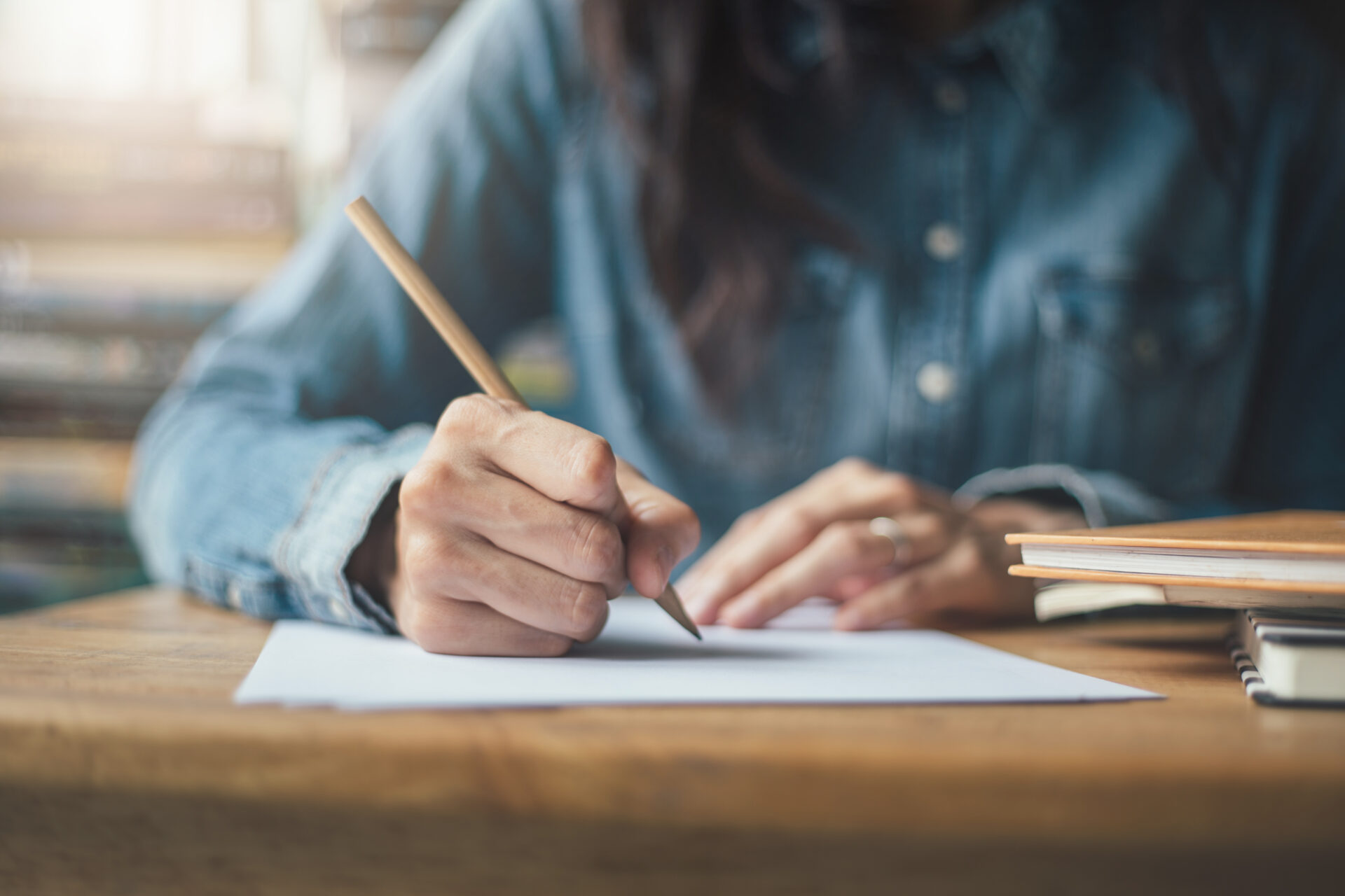 Woman professional taking a psychometric paper test and circling answer with wooden pencil sitting at a desk.