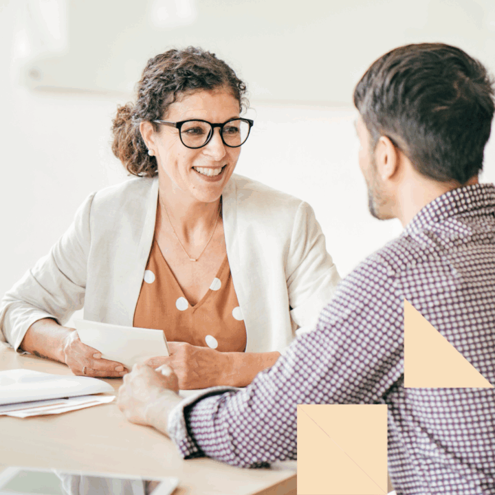Smiling recruiter conducting a direct hire interview with a candidate in an office setting, highlighting the advantages of direct hire recruitment.