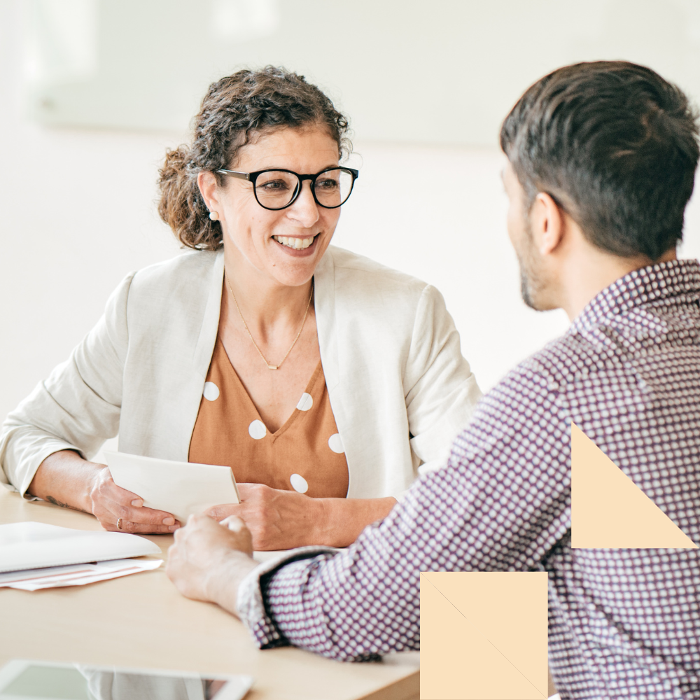 Smiling recruiter conducting a direct hire interview with a candidate in an office setting, highlighting the advantages of direct hire recruitment.