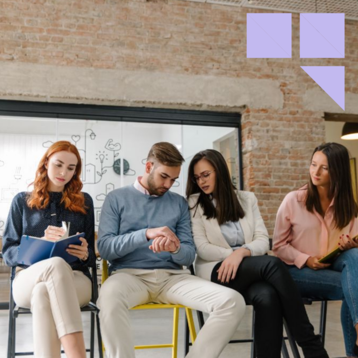Engaged job candidates sitting and waiting for job interview inside an office with resumes in their hands