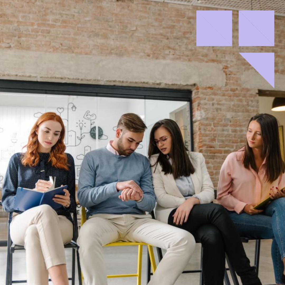 Engaged job candidates sitting and waiting for job interview inside an office with resumes in their hands