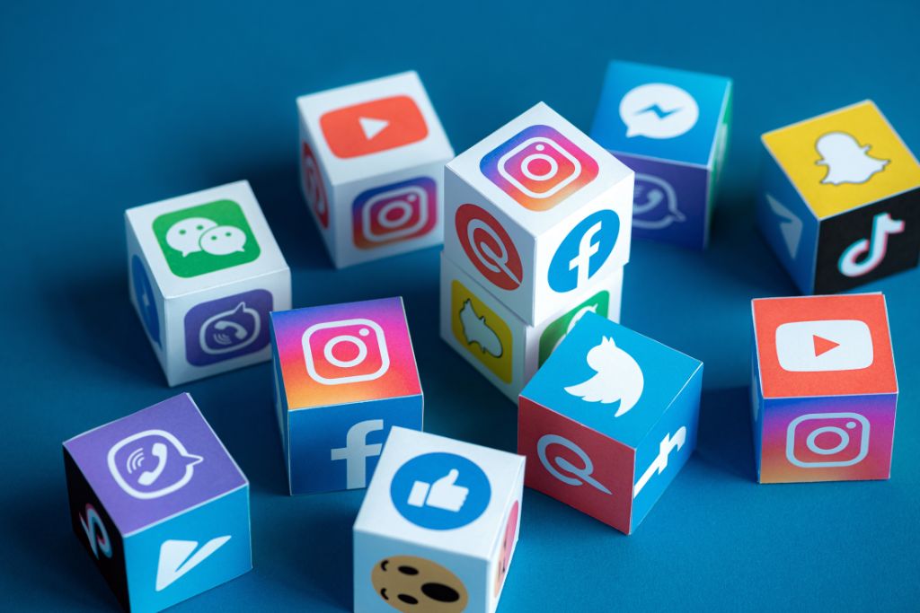 Social media platform icons on blocks, such as Facebook, YouTube, X, Instagram, Snapchat, and TikTok for social recruiting concept.