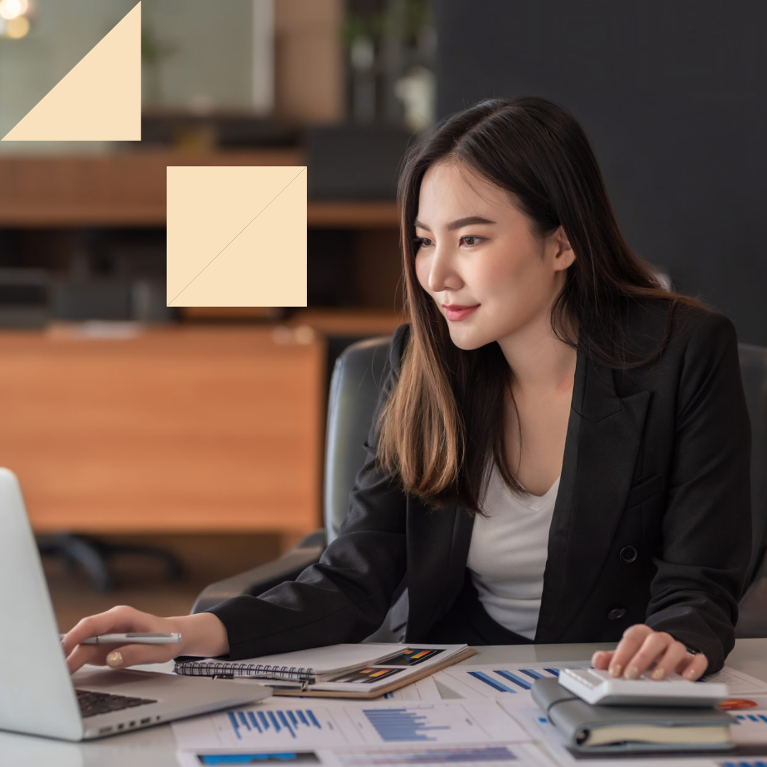 Female accountant crunching number on her laptop and taking notes at her desk