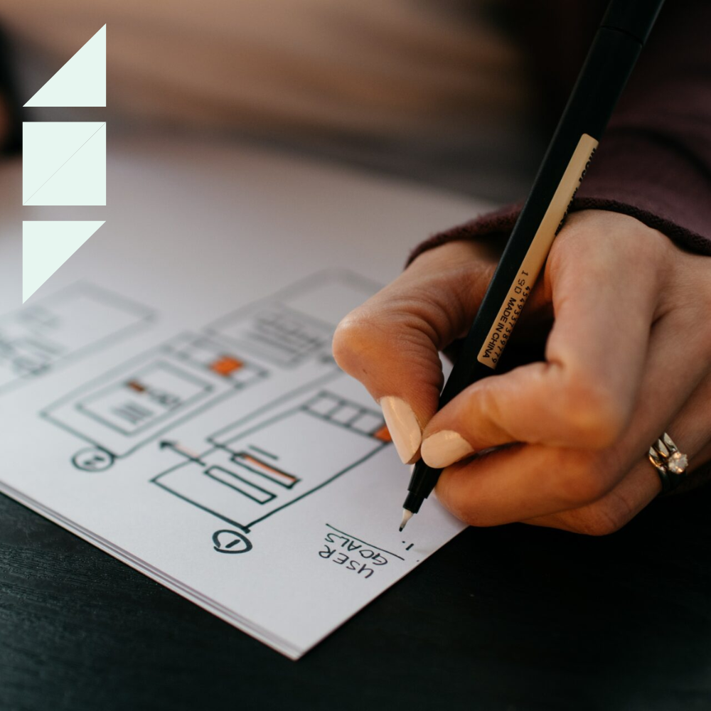 Woman with a pen in her hand creating a staffing plan on a white sheet of paper