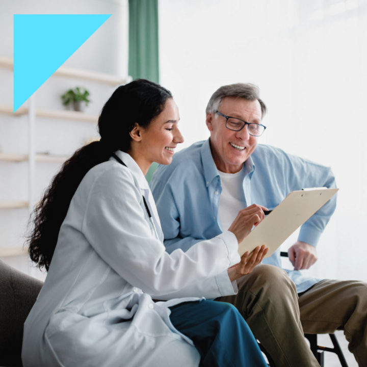 Female insurance nurse showing elderly male patient policy options on a notebook