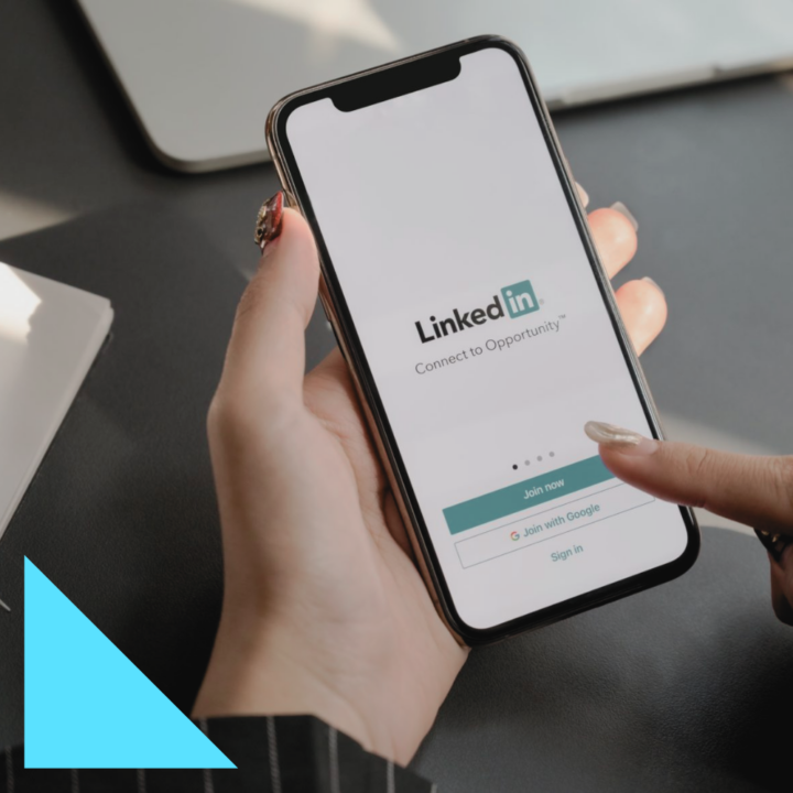 female touching iPhone signing on to LinkedIn