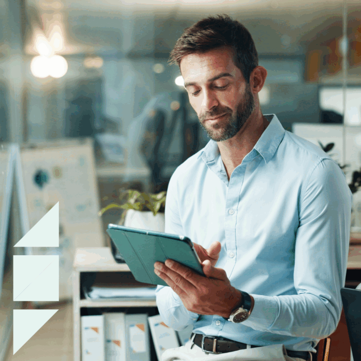 Professional business analyst reviewing data on a tablet in a modern office—how to hire a business analyst who brings insight and value to your organization.
