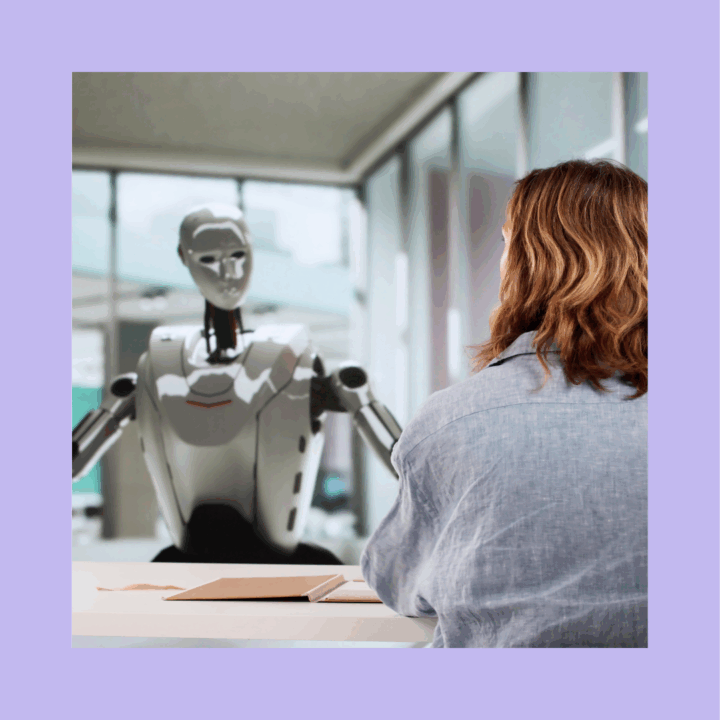 Hiring manager sitting across from a humanoid robot during an interview, symbolizing the use of AI in modern recruiting.