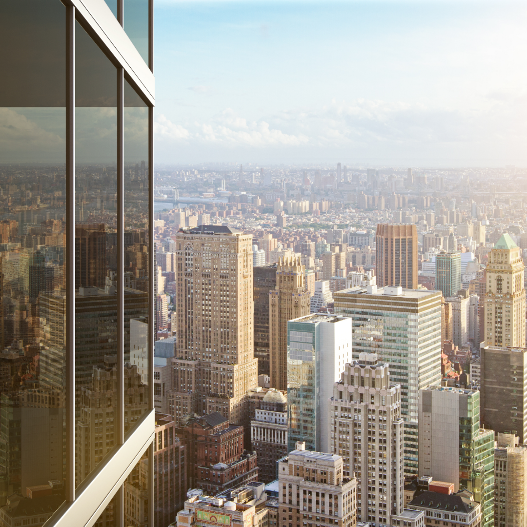 Sunlit city skyline viewed from a modern office building window, symbolizing shifts in the job market, corporate growth, and economic change.