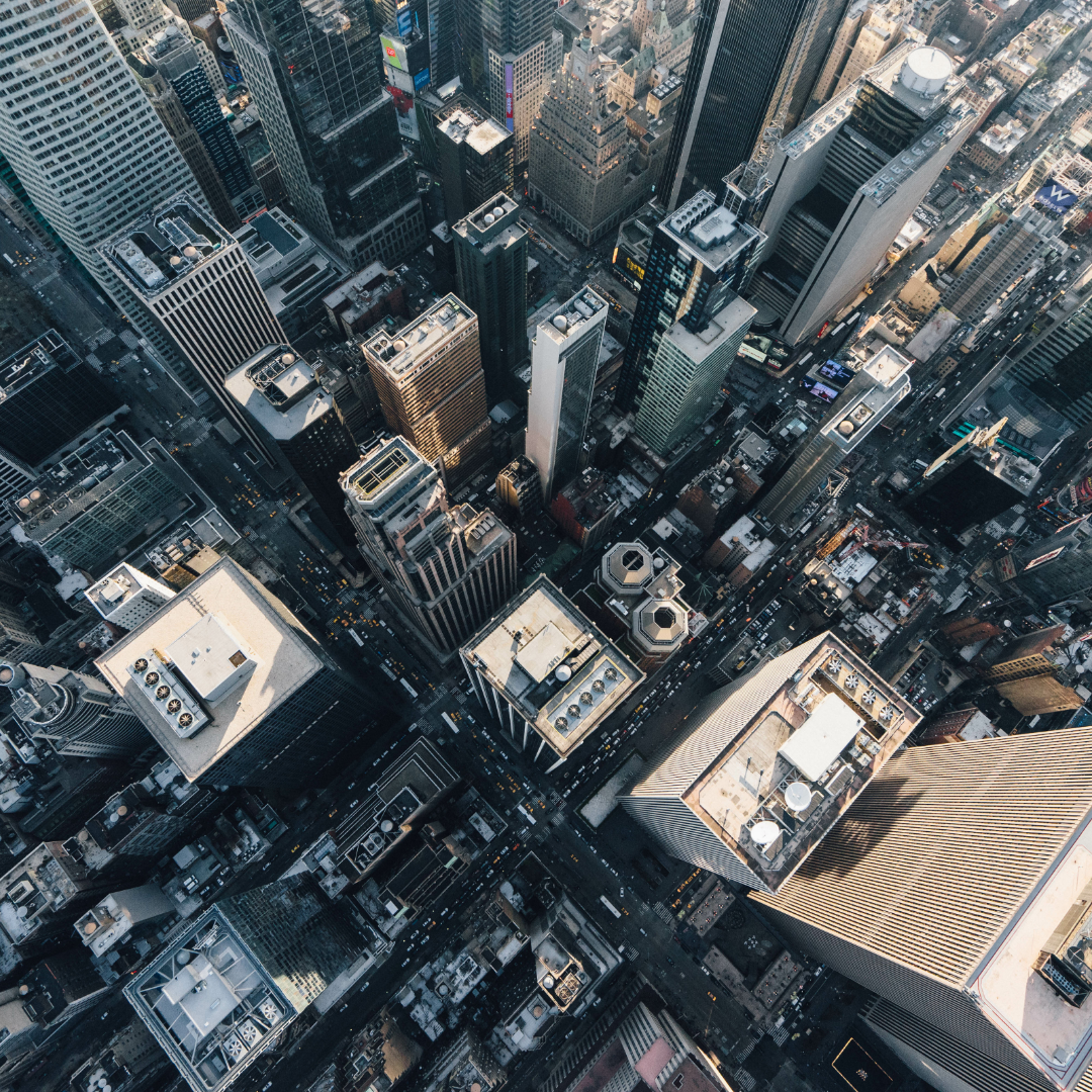 Aerial view of a dense urban city center with skyscrapers and busy streets, representing employment trends, economic activity, and the broader job market.