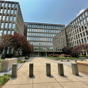 Modern office complex with glass-fronted buildings surrounding a landscaped courtyard, representing the U.S. tech workforce and corporate office environment.