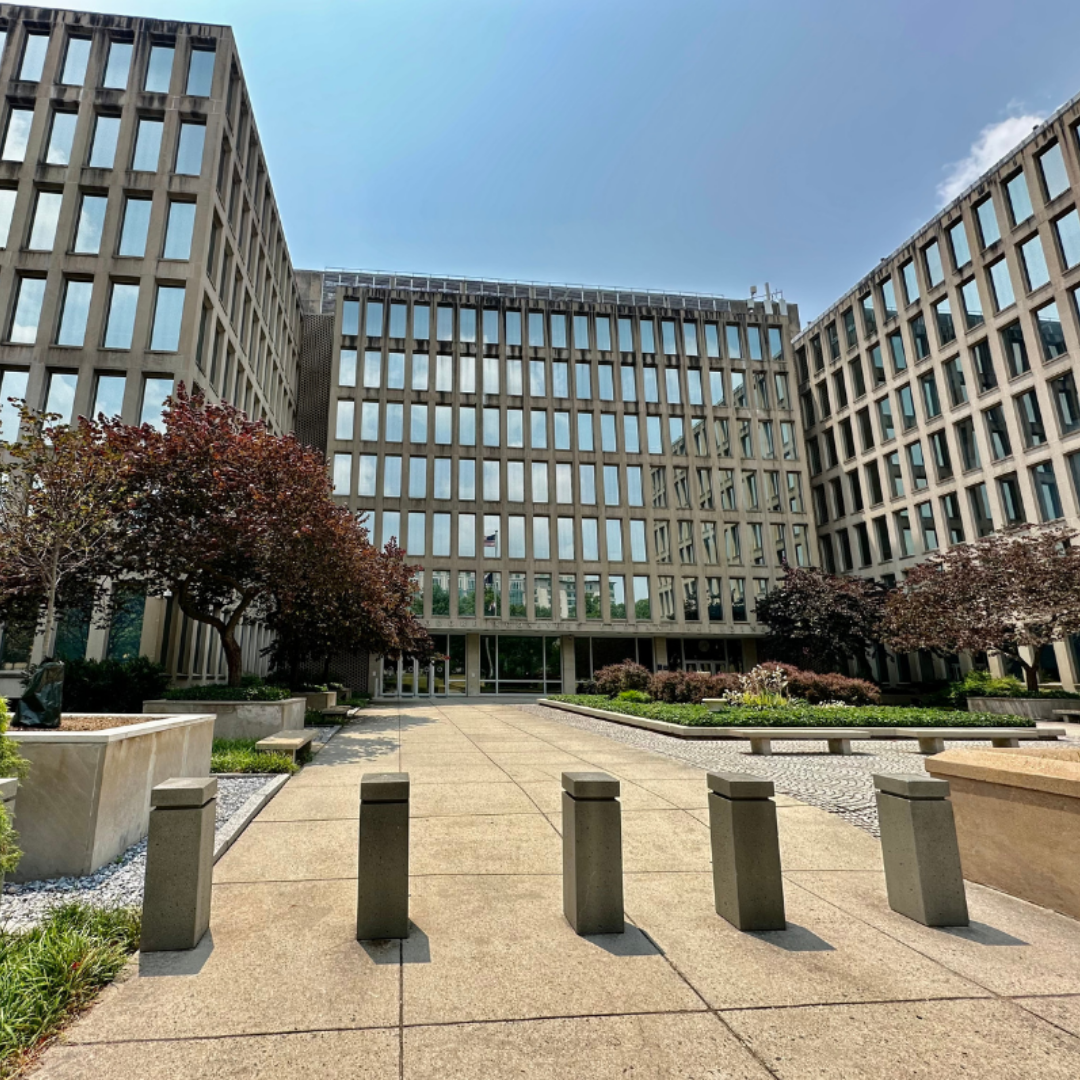 Modern office complex with glass-fronted buildings surrounding a landscaped courtyard, representing the U.S. tech workforce and corporate office environment.