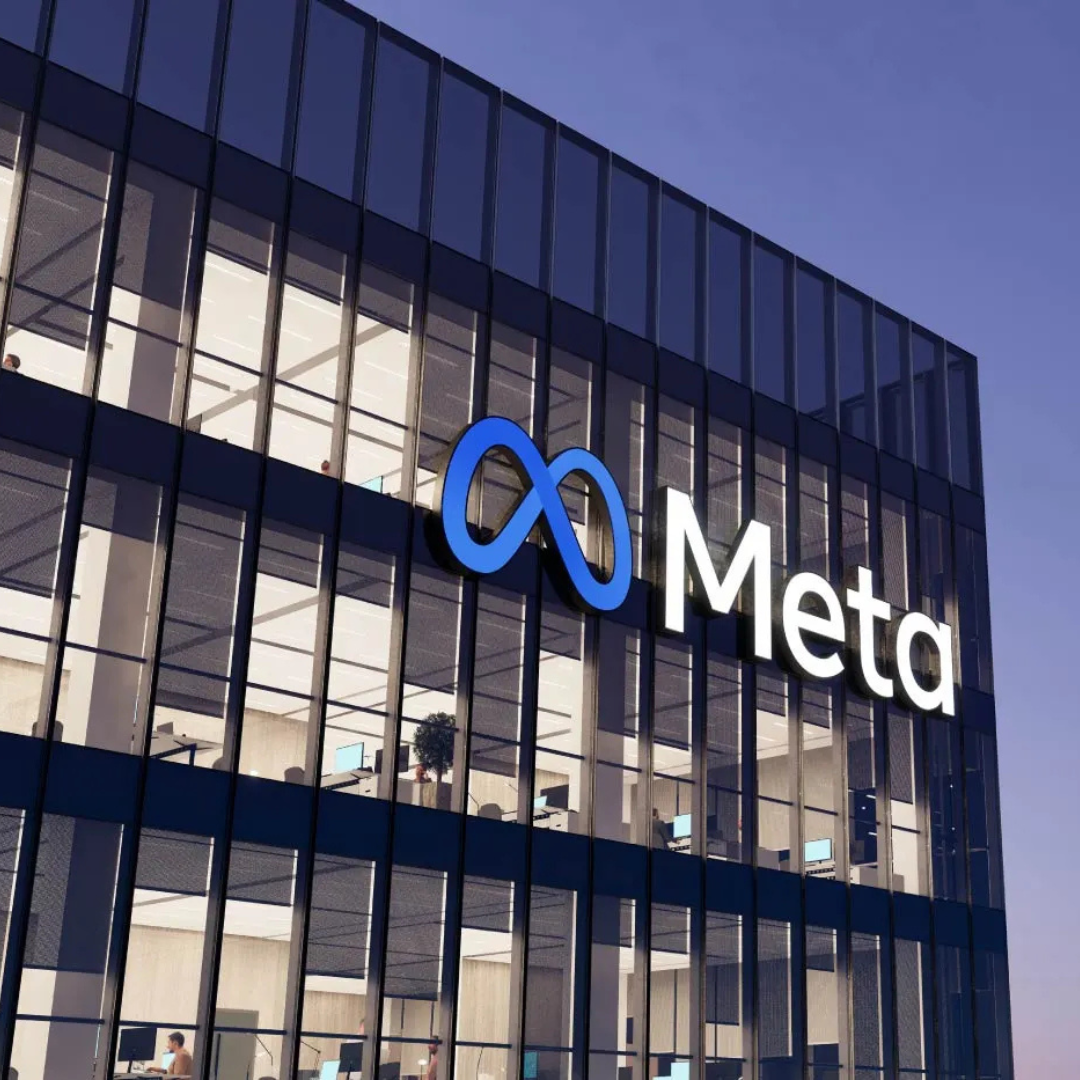 Exterior view of a modern office building with the Meta logo displayed prominently on the glass facade
