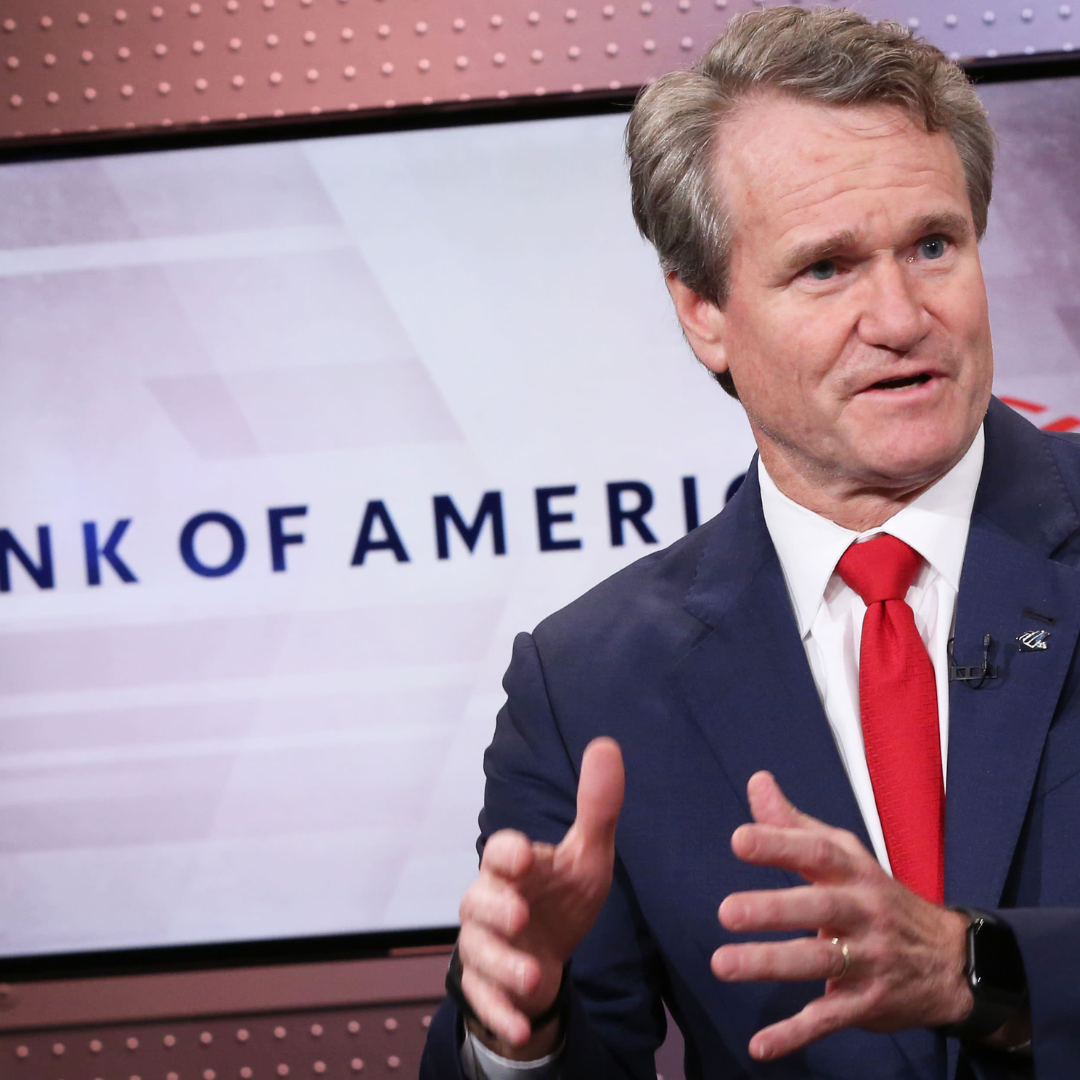Bank of America CEO Brian Moynihan speaking during an interview, gesturing with his hands in front of a branded backdrop