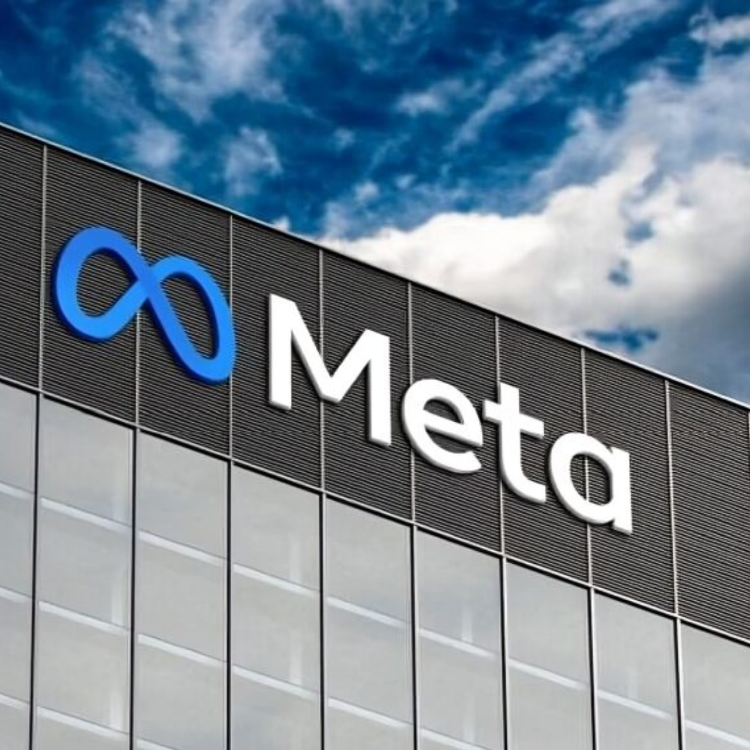 Meta company logo displayed on the exterior of a modern office building against a blue sky.