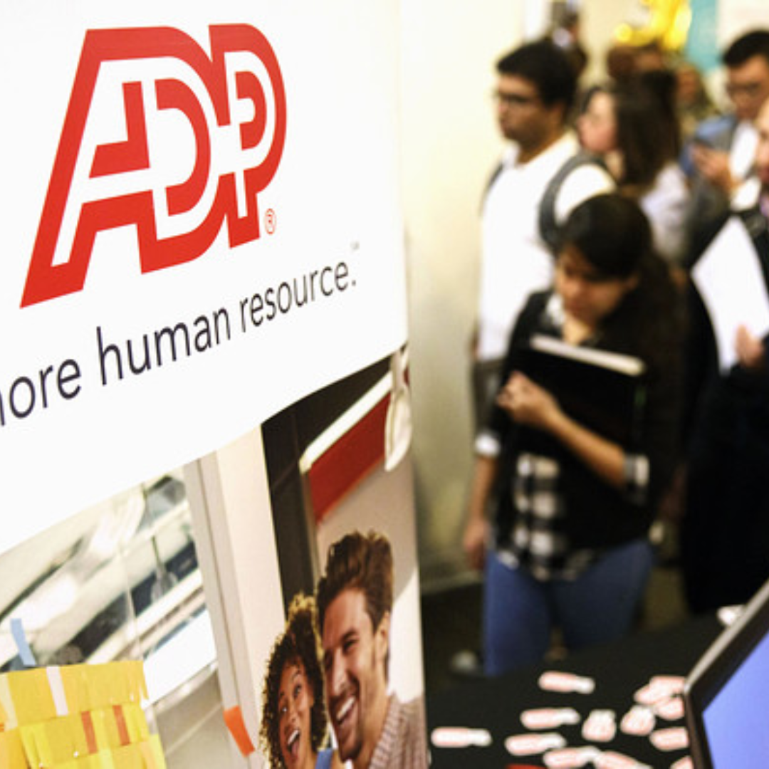 ADP hiring and recruiting display at a career event, with job seekers walking through the background