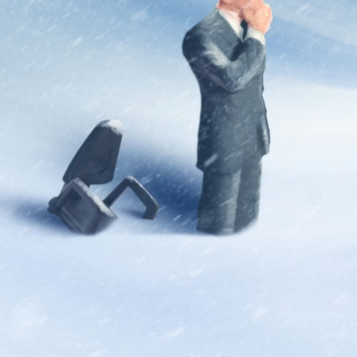 Miniature figurine of a businessman in a suit standing in snow beside a fallen briefcase, illustrating a frozen job market