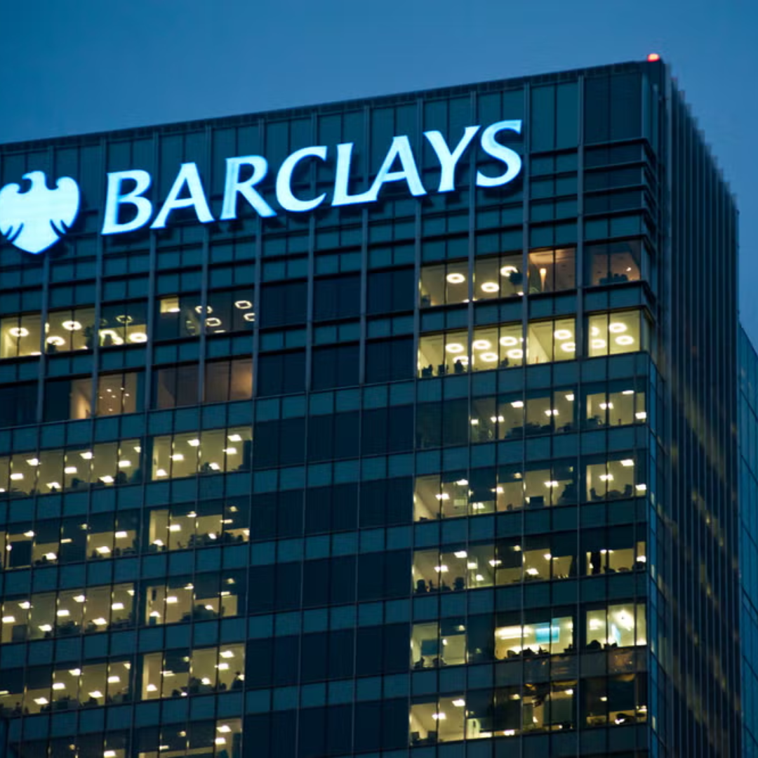 Barclays corporate office building illuminated at night with the Barclays logo and eagle emblem on the exterior