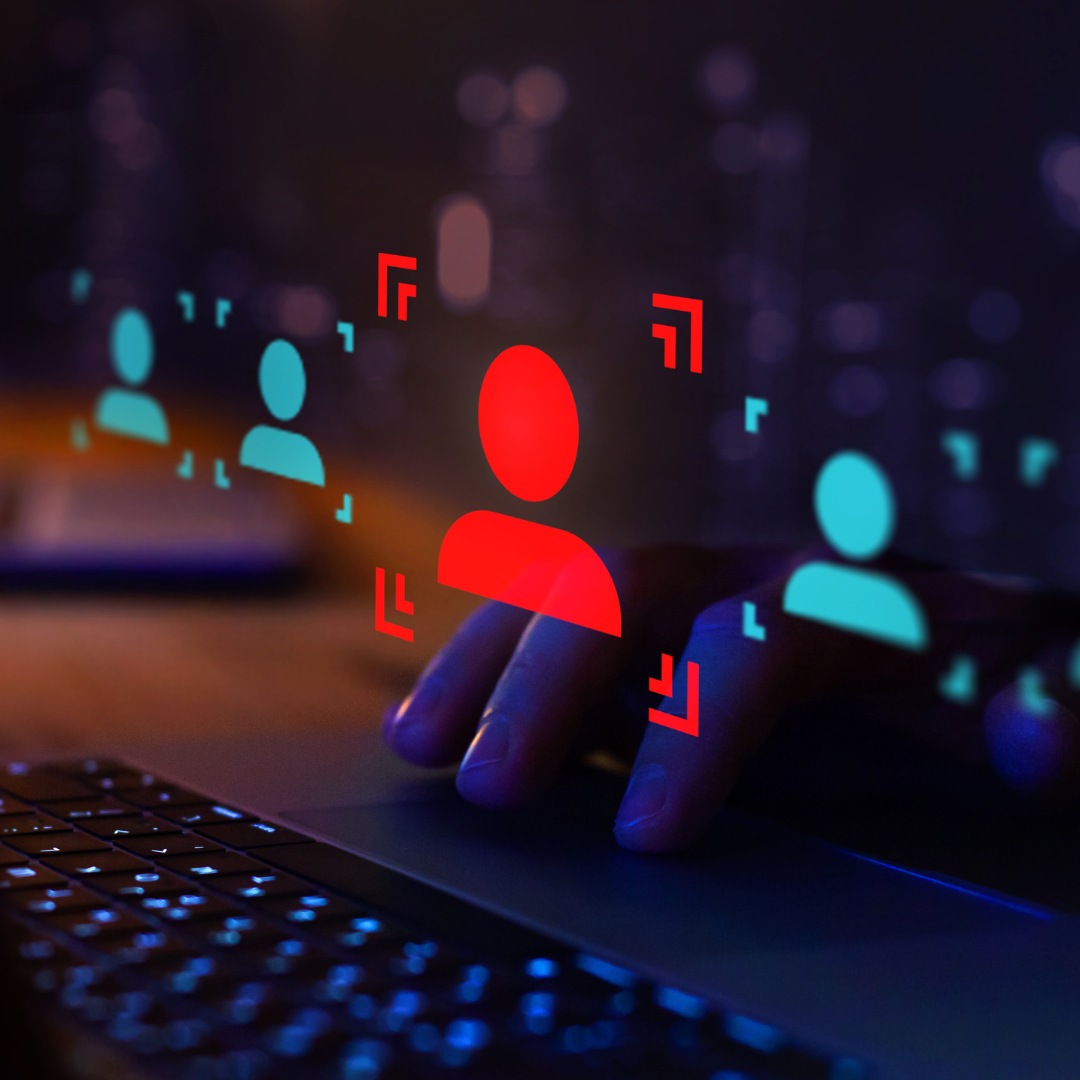 Hand on a laptop trackpad selecting a highlighted red user profile icon among multiple digital candidate icons, representing hiring fraud or candidate fraud